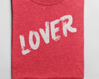 Op de afbeelding: Rood T-shirt met het woord "LOVER" in wit op de voorkant.