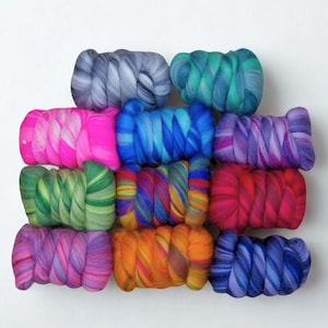 May include: A collection of colorful wool roving in various shades, including pink, blue, green, and orange. The wool is arranged in neat rows, showcasing the vibrant hues and textures of the fiber. Ideal for fiber art projects.