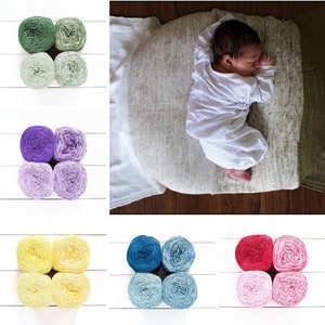 May include: Six sets of yarn balls in different colors, including green, purple, yellow, blue, and pink. Each set has two balls of yarn.