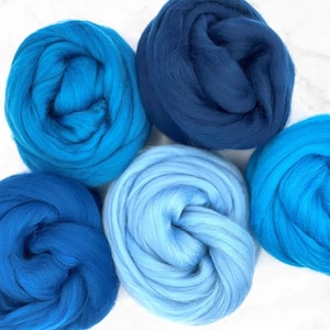May include: Five balls of wool yarn in shades of blue. The yarn is soft and fluffy, perfect for knitting or crocheting.