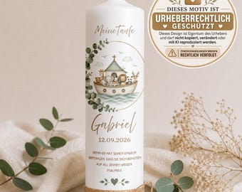 Op de afbeelding: Een witte cilindrische stompkaars met een illustratie van een ark vol dieren, omringd door een groene eucalyptuskrans. De tekst bevat Meine Taufe, Gabriel, 12.09.2026 en een Duits bijbelvers. De onderkant is omwikkeld met touw.