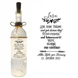 Könnte beinhalten: Eine durchsichtige Glasflasche mit einem Korkverschluss und einer Schnur, die um den Hals gewickelt ist. Die Flasche ist mit weißen Lichterketten gefüllt. Ein Etikett auf der Flasche lautet "Lara" und enthält den Text "LEBE DEINE TRÄUME und geh deinen Weg! Du bist einzigartig und liebenswert! HOFFE, GLAUBE UND VERTRAUE! Alles Liebe zur Firmung 22. OKTOBER 2022".