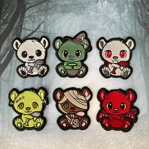 May include: Six embroidered iron-on patches featuring cute cartoon bears dressed in Halloween costumes. The bears are wearing costumes such as a witch, a mummy, a zombie, a devil, and a vampire.