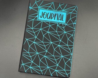 Può includere: Diario nero con un motivo geometrico blu e la parola "JOURNAL" stampata in un rettangolo blu sulla copertina.