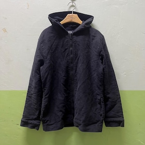 Peut inclure: Veste à capuche noire avec fermeture éclair intégrale. La veste a un design simple avec une capuche et deux poches avant. Le nom de la marque "A.P.C." est visible sur la poitrine. La veste est suspendue à un cintre en bois.
