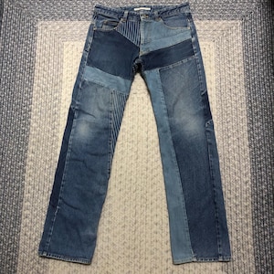 May include: Blue denim jeans with a patchwork design. The jeans are made of different shades of blue denim and have a straight leg.