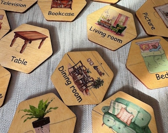 May include: Wooden puzzle pieces with illustrations of household items and rooms, including a television, bookcase, and sofa. Each piece is labeled with a corresponding word, such as "Garden," "Bathroom," and "Living room."