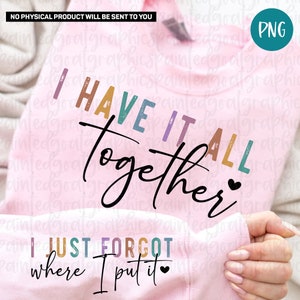 May include: A pink sweatshirt with the text "I have it all together" in rainbow colors and a heart. Below the text is "I just forgot where I put it" also in rainbow colors and a heart.