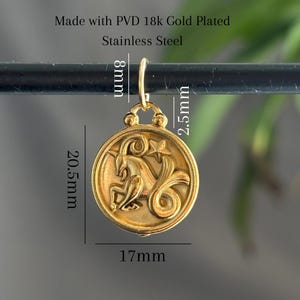 Może przedstawiać: Pozłacany wisiorek ze stali nierdzewnej z motywem zodiakalnego Koziorożca. Okrągła zawieszka ma 17 mm szerokości i 20,5 mm wysokości, z pętelką 8 mm i haczykiem 2,5 mm. Wisiorek przedstawia szczeg&oacute;łowy wizerunek Koziorożca.