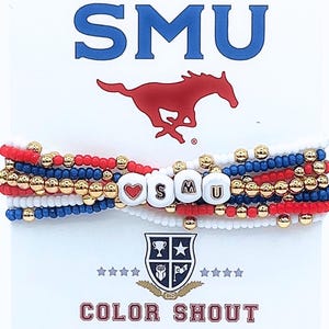 May include: A set of five colorful beaded bracelets with gold beads and white beads. The bracelets spell out "SMU" with a heart bead in front of the "S". The bracelets are on a white background with the words "SMU" and a red and white horse logo above the bracelets. Below the bracelets is a shield logo with the words "COLOR SHOUT".