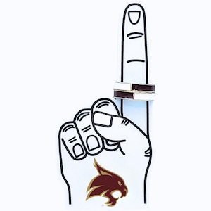 May include: A white foam finger with a maroon and gold logo, pointing upwards, with two rings on the index finger. The rings have a white and brown band with a gold band in between.