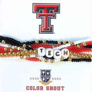 May include: A multi-strand beaded bracelet with black, white, and red beads. The bracelet has a charm with the word "TECH" in gold letters. The bracelet is displayed on a white background with a red and black Texas Tech University logo.