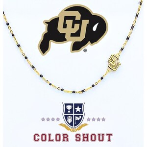 May include: Gold-toned necklace with black accents and a pendant featuring the CU logo. The necklace is displayed against a white background with the Colorado Buffaloes logo and the words "COLOR SHOUT".
