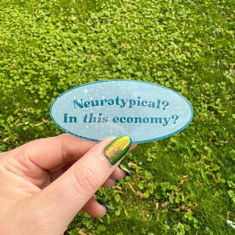 May include: A blue and white oval sticker with the text "Neurotypical? In this economy?" on a green grassy background.