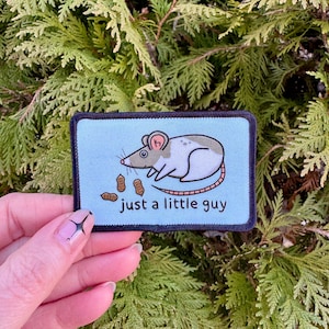 May include: A blue and white embroidered patch with a cartoon mouse holding peanuts and the text "just a little guy".