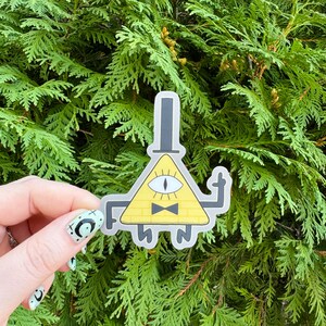 May include: Yellow triangle-shaped character with one eye, a black bow tie, and a black top hat. The character is giving the middle finger. The character is a sticker.