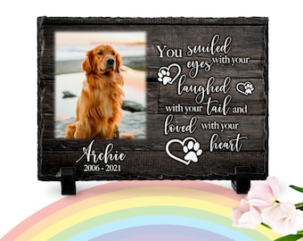 May include: A black slate memorial plaque with a photo of a golden retriever dog. The plaque has the text "You smiled eyes with your laughed with your tail and loved with your heart" and the name "Archie" with the dates "2006-2021".