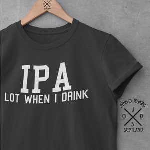 Puede incluir: Una camiseta gris oscuro con texto blanco que dice "IPA LOT WHEN I DRINK". La camiseta tiene un pequeño logotipo en la manga derecha que dice "JOHN O DESIGNS" con una cruz y las palabras "SCOTLAND".