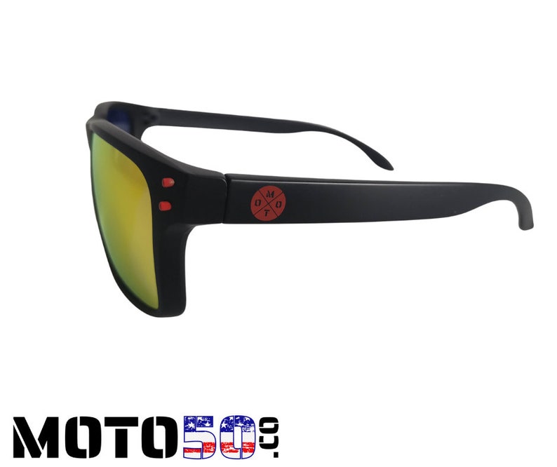May include: Black sunglasses with a red logo that says "MOTO" with a cross inside the "O". The lenses are yellow.