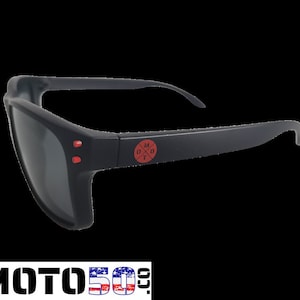 May include: Black sunglasses with red accents and a red logo that says "M0T0" with a cross inside the "O".