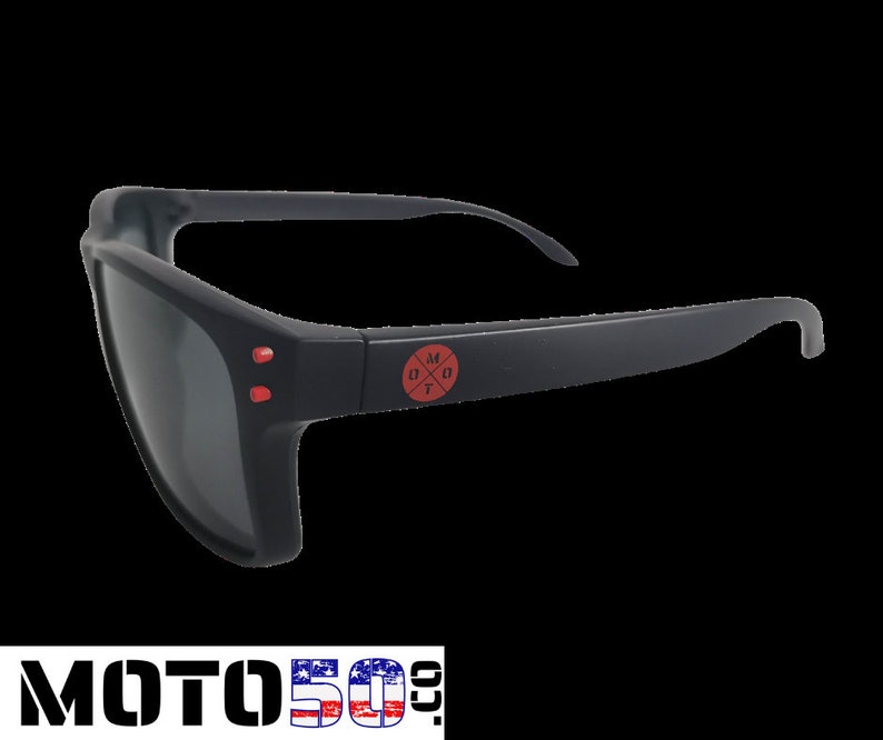 May include: Black sunglasses with red accents and a red logo that says "M0T0" with a cross inside the "O".