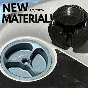 May include: Close-up of a mechanical part with the text "NEW MATERIAL!" and the date "4/1/2026". The part has a dark gray, three-pronged component and a circular, blue-gray piece with the text "T30 5Nm".