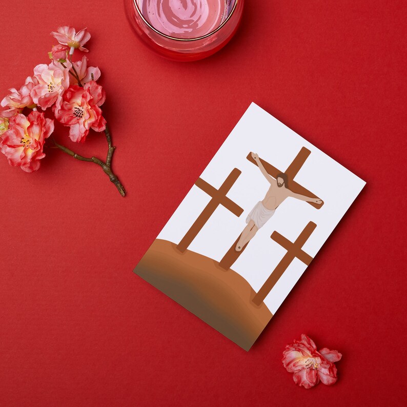 May include: A white card with a brown illustration of three crosses and a figure of Jesus Christ on the center cross. The card is on a red background with pink flowers.