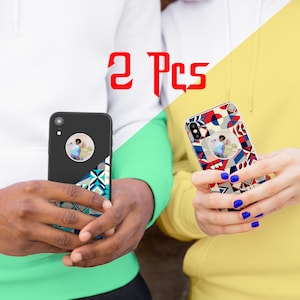 May include: Two phone cases with a geometric pattern and a photo insert. The cases are black and white with blue and red accents. The text "2 Pcs" is displayed in red.