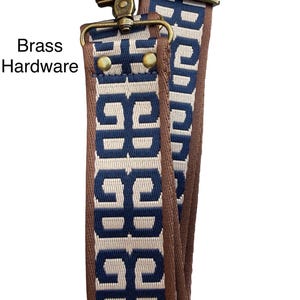 May include: A replacement bag strap featuring a woven pattern of dark blue geometric shapes on a cream background with brown fabric edges. The strap includes brass hardware, specifically a swivel lobster clasp and a sliding adjuster buckle.