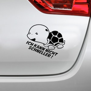 Può includere: Adesivo in bianco e nero di una tartaruga dei cartoni animati con il testo "ICH KANN NICHT SCHNELLER!" su un'auto bianca.