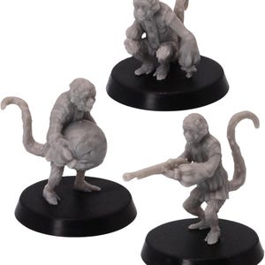 Puede incluir: Tres figuras en miniatura grises de criaturas parecidas a monos en varias poses. Una está en cuclillas, otra sostiene una gran esfera y la tercera apunta con un arma pequeña. Cada figura está montada sobre una base circular negra.