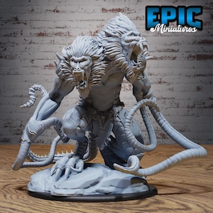 Op de afbeelding: Een lichtgrijze miniatuurfiguur van een monsterlijk wezen met twee aapachtige hoofden, scherpe tanden en een gespierd lichaam. De figuur heeft lange, gesegmenteerde staarten en staat op een rotsachtige basis. De tekst "EPIC Miniatures" staat in de rechterbovenhoek.