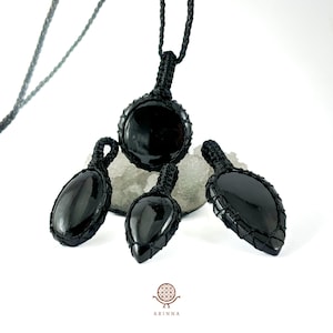 Peut inclure: Quatre pendentifs en obsidienne noire avec des cordons noirs. Les pendentifs sont de formes variées, notamment rondes, en forme de larme et de feuille.