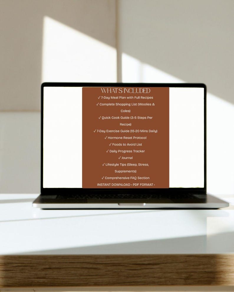 May include: A laptop displays a brown graphic with white text listing the contents of a digital download. The text includes a 7-day meal plan, shopping list, exercise guide, and more. The laptop is on a white surface.