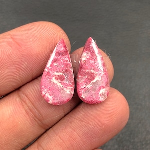 May include: Pair of pink and white teardrop shaped cabochon gemstones.