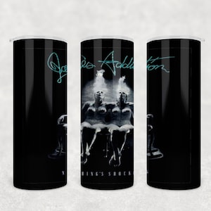 May include: A black and white photograph of two women sitting on chairs. The photo is on a black tumbler with the text "Joe Addistion Nothing's Shock" and a signature.