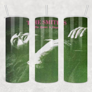 May include: A green and white tumbler with a design of a person's face and hand. The text "The Smiths" and "The Queen Is Dead" is printed on the tumbler.