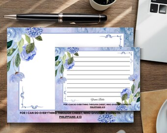 May include: Stationery set featuring a floral design with blue watercolor flowers and green leaves. The set includes a notepad and a lined writing pad. The text "FOR I CAN DO EVERYTHING THROUGH CHRIST, WHO GIVES ME STRENGTH. PHILIPPIANS 4:13" is printed on the stationery.