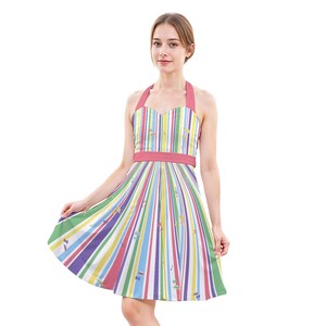 May include: A multi-coloured striped halter dress featuring vertical stripes in shades of pink, purple, yellow, and green. The dress has a pink halter neck and a pink belt at the waist. The skirt flares out, and the dress is made of a lightweight fabric.