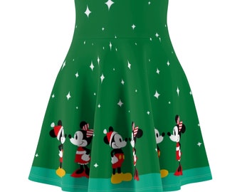 Pode incluir: Uma saia verde com uma estampa de Natal com Mickey Mouse e Minnie Mouse. A saia tem um padrão de estrelas brancas e uma bainha verde e branca.