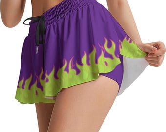 May include: Purple skort with a neon green flame design along the bottom edge. The skort has a drawstring waist and is paired with matching shorts underneath. The design is a vibrant and eye-catching combination.