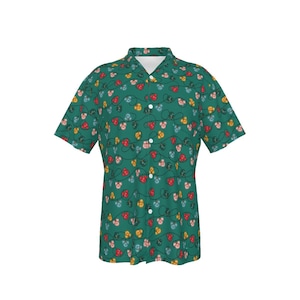 May include: A short-sleeved button-down shirt with a green background and a repeating pattern of colorful, stylized light bulbs. The bulbs are red, yellow, and blue, connected by black lines. The shirt has a classic collar and white buttons.