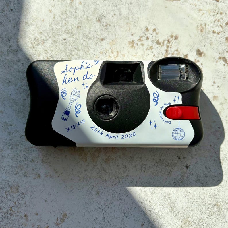 Personalised hen party disposable camera wrap with blue line art illustrations on a Kodak FunSaver camera.  Shown on a brown stone background with the light catching the details in an editorial fashion.