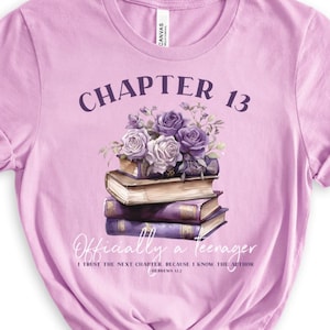 May include: A light purple t-shirt with the text "Chapter 13 Officially a Teenager I trust the next chapter because I know the author Jeremiah 29:11" and a graphic of a stack of books with purple flowers.