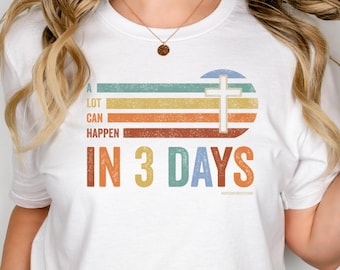 Pode incluir: Camiseta branca com um design gráfico de estilo vintage que apresenta uma cruz e o texto "A lot can happen in 3 days".