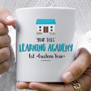 May include: White ceramic mug with a blue and white house illustration, the text "LEARNING ACADEMY" and the words "Est. *Custom Year*" in black text.
