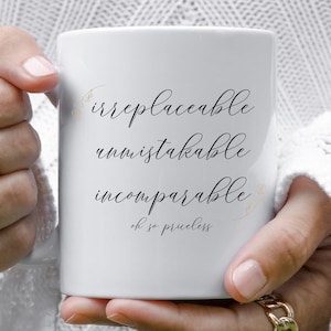 May include: White ceramic mug with black calligraphy that reads "irreplaceable, unmistakable, incomparable, oh so priceless".