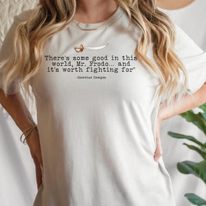 May include: White t-shirt with a quote from the Lord of the Rings: "There's some good in this world, Mr. Frodo... and it's worth fighting for" -Samwise Gamgee.