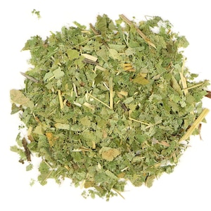May include: A close-up of a pile of dried green and brown herbs, likely for tea or herbal remedies.