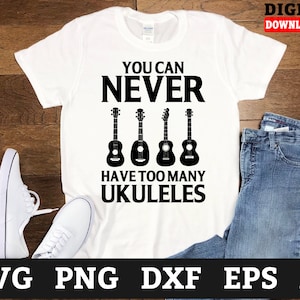 Puede incluir: Camiseta blanca con texto negro que dice "You can never have too many ukuleles". Debajo del texto se muestran cuatro ukeleles negros.